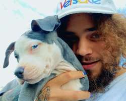 The star is accompanied by a cute dog in his home.