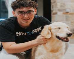 The star is accompanied by a big dog in his home.